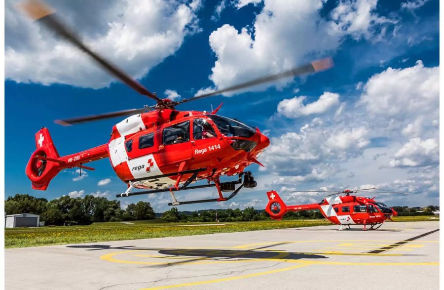 Zwei Rega Helikopter auf Landeplatz - Keystone