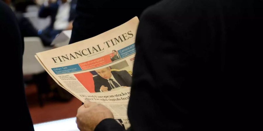 Ein Mann hält eine «Financial Times».