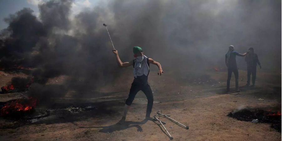 Palästinenser schleudern Steine gegen israelische Truppen.