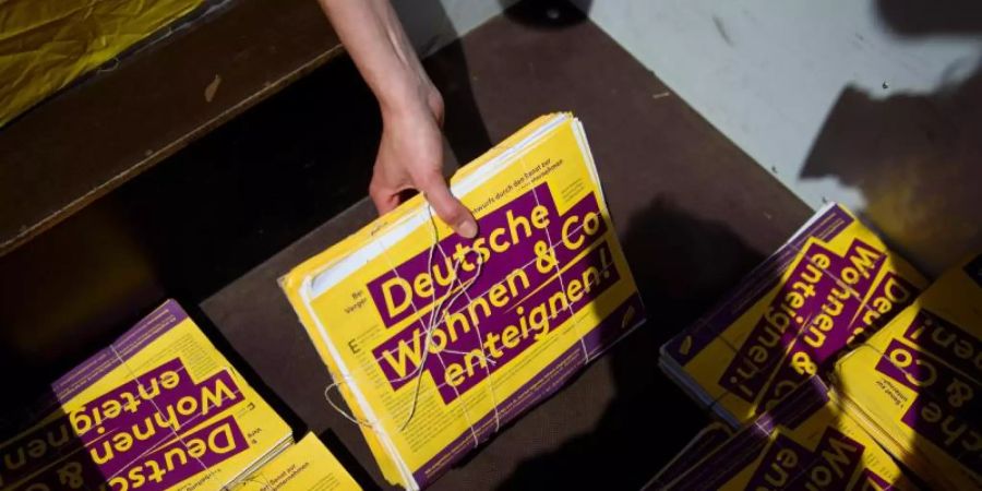 Freiwillige Helferinnen und Helfer der Initiative «Deutsche Wohnen & Co enteignen» mit einem Stapel von Unterschriften. Foto: Gregor Fischer/dpa