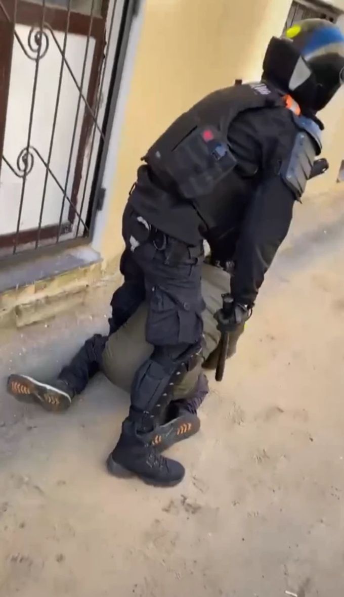 Auf dem Bild ist zu sehen, wie ein russischer Polizist einen Demonstranten festnimmt. Ukraine Krieg