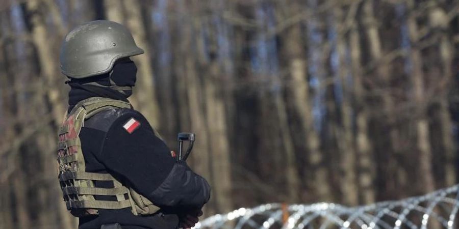 Ein bewaffneter polnischer Soldat bewacht in der Nähe des Ortes Usnarz Gorny die EU-Aussengrenze zu Belarus. Foto: Doris Heimann/dpa