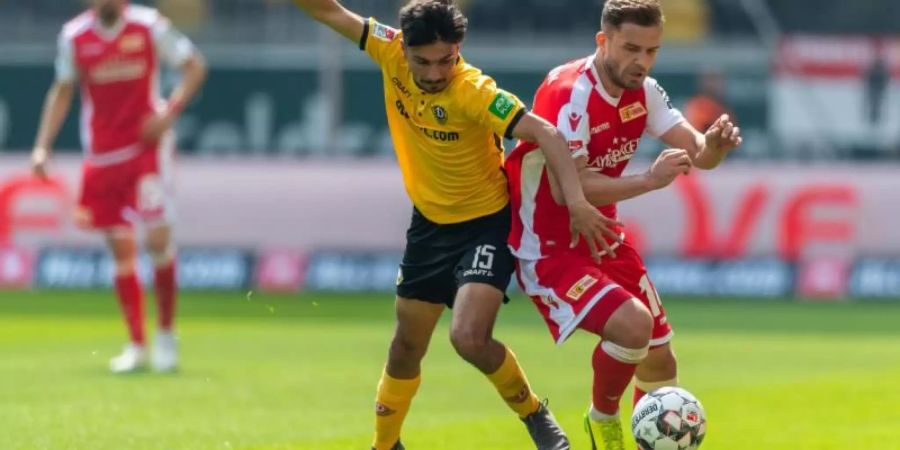 Osman Atilgan (l) von Dynamo Dresden kämpft gegen Union-Spieler Ken Reichel um den Ballbesitz. Foto: Robert Michael/dpa-Zentralbild/dpa