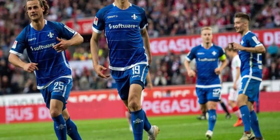 Die Spieler von Darmstadt 98 feiern das 1:0 beim FC Köln. Foto: Marius Becker/dpa