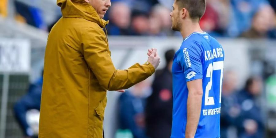 Hoffenheims Trainer Julian Nagelsmann (l) spricht während eines Spiels mit Andrej Kramaric. Foto: Uwe Anspach