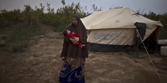 Eine Frau hält am 4.8.15 an der syrischen Grenze ein Baby im Arm. Frau Baby in Syrien