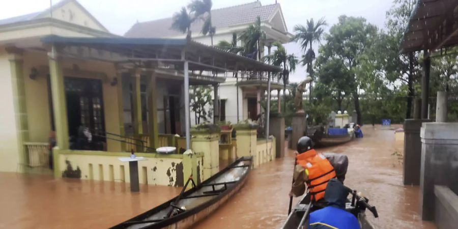 Rettungskräfte fahren mit einem Boot durch ein überflutetes Dorf. Bei anhaltendem Regen und schweren Überflutungen in Vietnam sind bis zum Montag mindestens 18 Menschen ums Leben gekommen. Foto: Ho Cau/VNA/AP/dpa