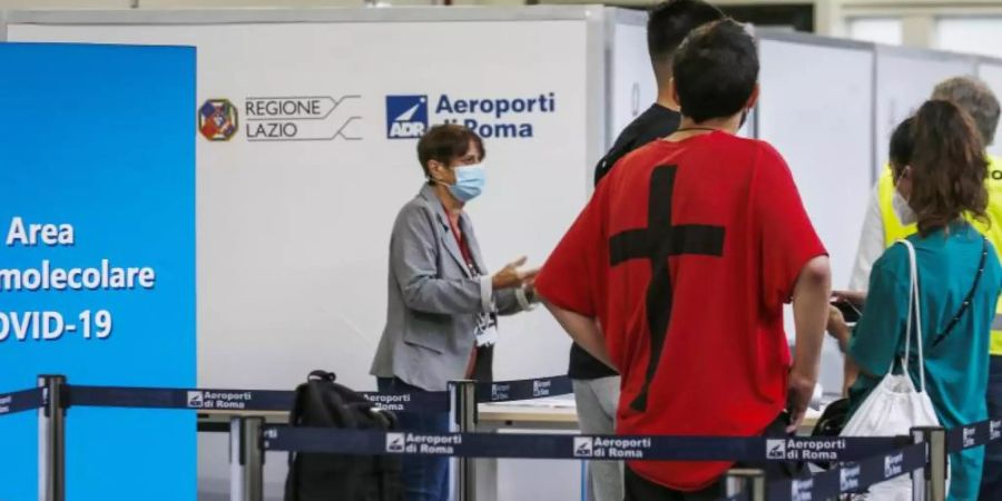 Passagiere warten in einer Schlange am Flughafen Ciampino auf einen Corona-Test. Foto: Cecilia Fabiano/LaPresse via ZUMA Press/dpa