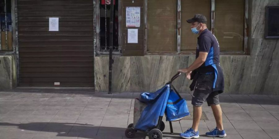Ein Lieferant geht vor einer Bar im spanischen Peralta vorbei, die geschlossen ist, um die Verbreitung des Coronavirus zu verhindern. Foto: Eduardo Sanz/EUROPA PRESS/dpa