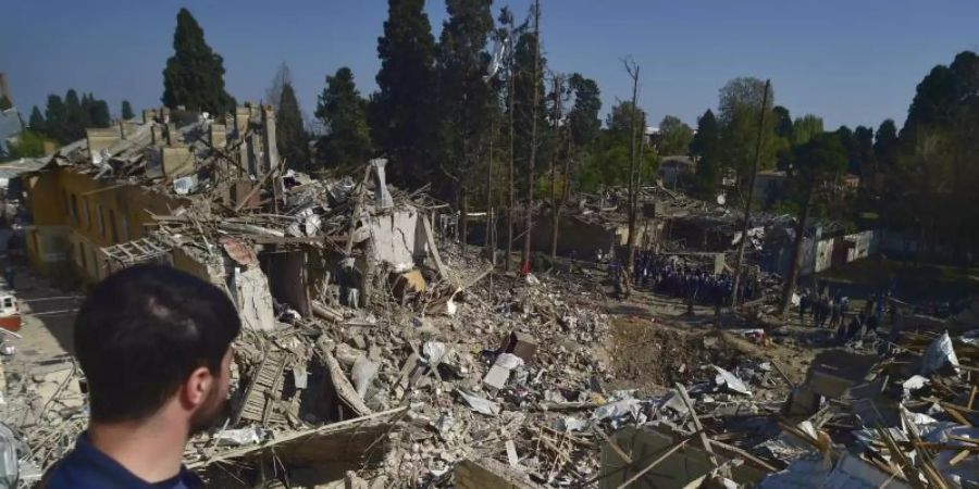 Ein Mann betrachtet die Überreste von Häusern, die durch armenischen Artilleriebeschuss zerstört wurden. Foto: Uncredited/AP/dpa