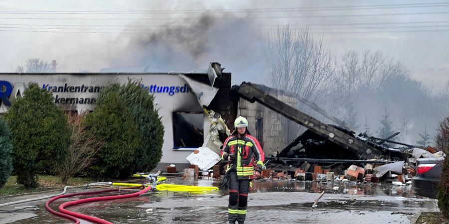 Ein Feuerwehrmann steht nach einer Detonation in einer Rettungswache vor Trümmern.