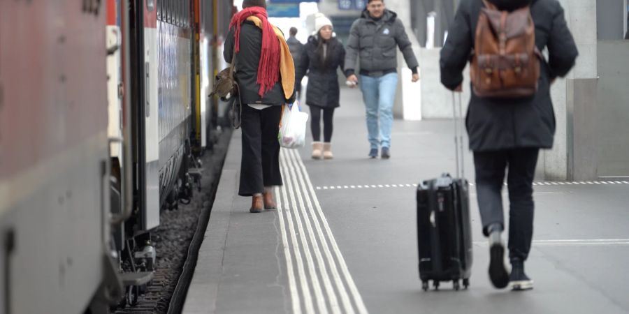 Zug Reisende an einem Bahnsteig. (Symbolbild)