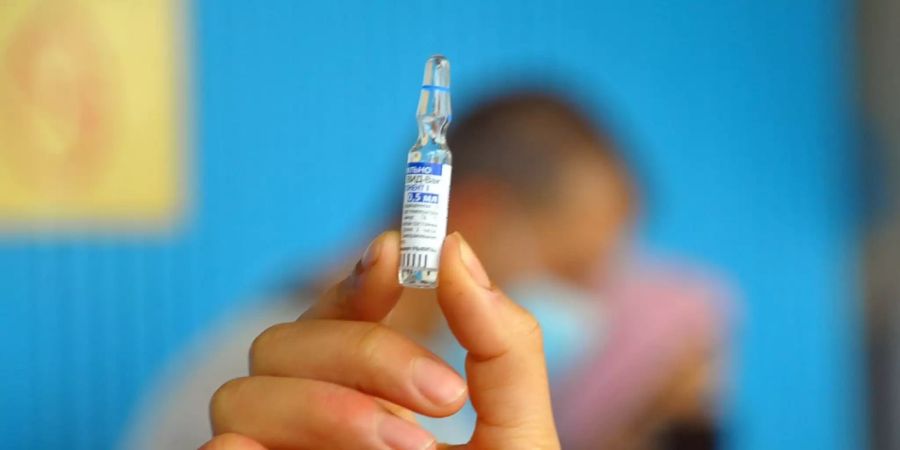 ARCHIV - Eine Mitarbeiterin eines Gesundheitsdienstes in Tunis hält ein Fläschchen mit dem Corona-Impfstoff «Sputnik V» aus Russland. Foto: Chokri Mahjoub/ZUMA Wire/dpa