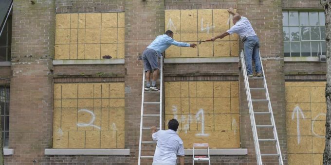 Ein Team deckt die Fenster entlang der Julia St. im Central Business District ab, während sich Hurrikan Ida der Küste von Louisiana in New Orleans nähert. hurrikan ida