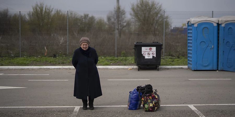 Helena steht neben ihren Habseligkeiten, nachdem sie vor den russischen Angriffen aus Mariupol in ein Flüchtlingszentrum  in Saporischschja geflohen ist. Foto: Leo Correa/AP/dpa