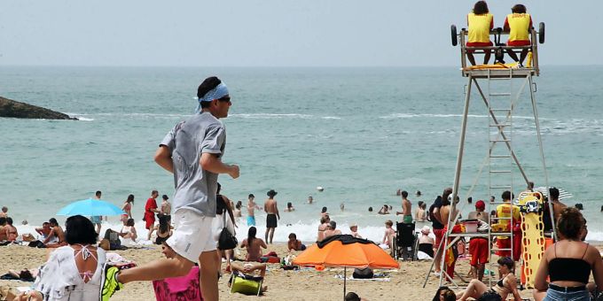 Ein Mann joggt an einem französischen Strand vorbei. frankreich
