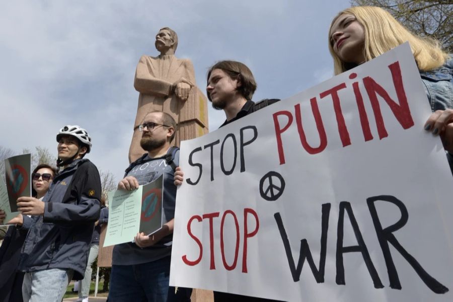 Demonstranten halten ein Antikriegsplakat während einer Antikriegs- und Anti-Putin-Kundgebung im Gorki-Park in Bischkek, Kirgisistan, am Samstag, 26. März 2022, in die Luft.