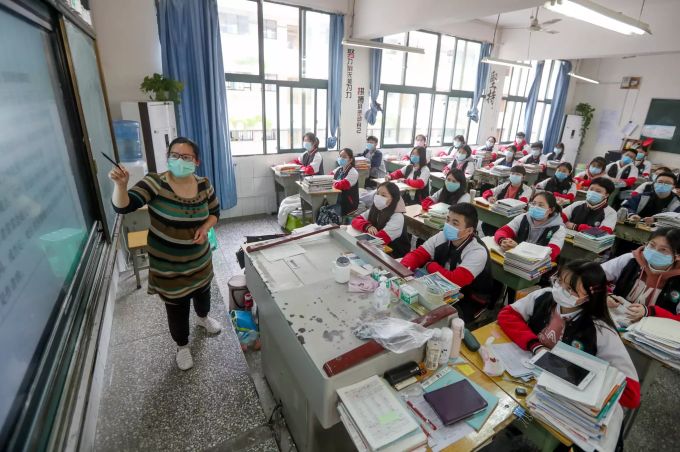 Schüler mit Schutzmasken nehmen in Chongqing am Unterricht teil. Einige Schüler können nach der Ausgangssperre aufgrund des Coronavirus die Schule wieder besuchen. Coronavirus - China