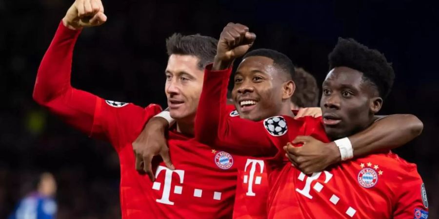 Torschütze Robert Lewandowski (l-r), David Alaba und Alphonso Davies jubeln über das 3:0 in London. Foto: Sven Hoppe/dpa