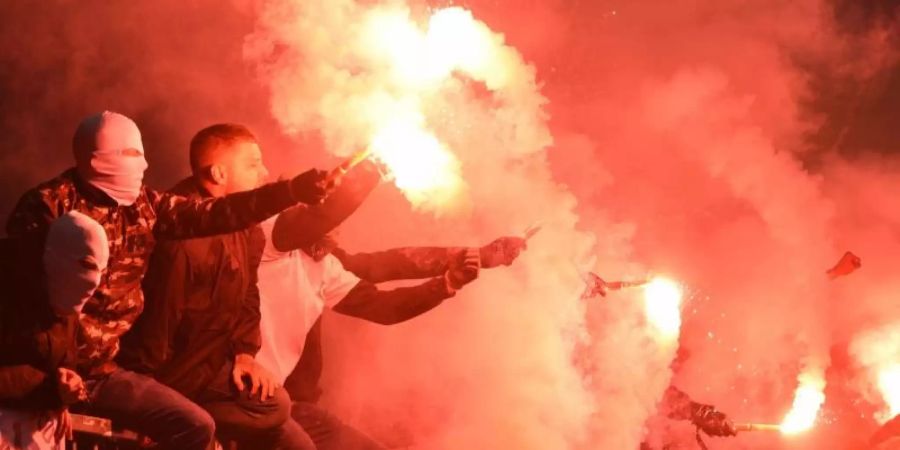 Fans zünden Pyrotechnik auf der Tribüne. Foto: Daniel Bockwoldt/dpa