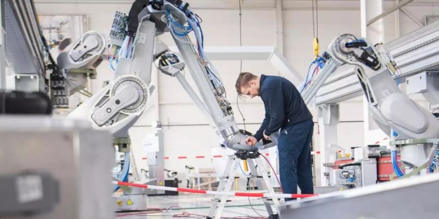 Ein Lackierroboter im Einsatz bei der Dürr AG. Unternehmen der deutschen Industrie haben zu Jahresbeginn mehr Aufträge erhalten, erwarten aber wegen der Corona-Krise keine rosige Zukunft. Foto: Sebastian Gollnow/dpa