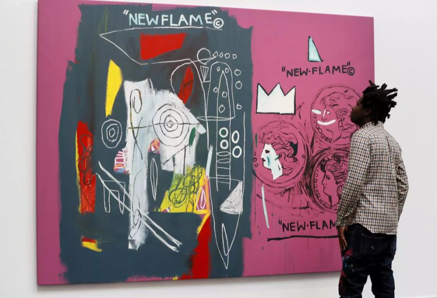 Ein Museumsbesucher betrachtet ein Gemälde von Jean-Michel Basquiat und Andy Warhol.