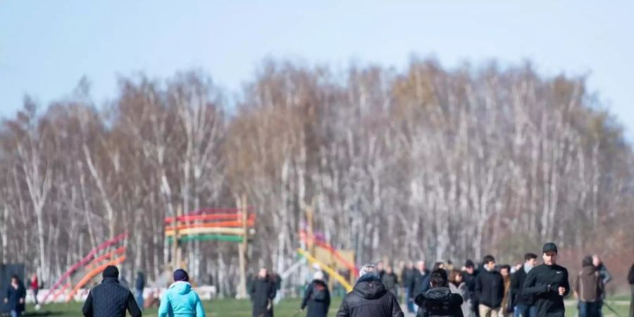 Menschen gehen trotz der Empfehlung des Gesundheitsministeriums zuhause zu bleiben, im Mauerpark in Berlin spazieren. Foto: Christophe Gateau/dpa