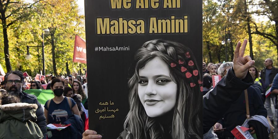 FILED - Ein Teilnehmer der Grossdemonstration in Berlin  ein Plakat mit der Aufschrift «We Are All Mahsa Amini» Aminis Tod löste weltweit Massenproteste aus. Photo: Paul Zinken/Deutsche Presse-Agentur GmbH/dpa