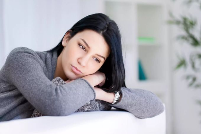 Das Fasten kann den Körper und Geist stärken und in depressiven Phasen helfen. Frau auf Sofa