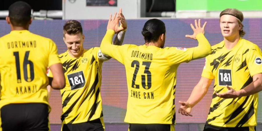 Dortmunds Matchwinner Erling Haaland (r) wird von seinen BVB-Teamkollegen in Wolfsburg gefeiert. Foto: Swen Pförtner/dpa