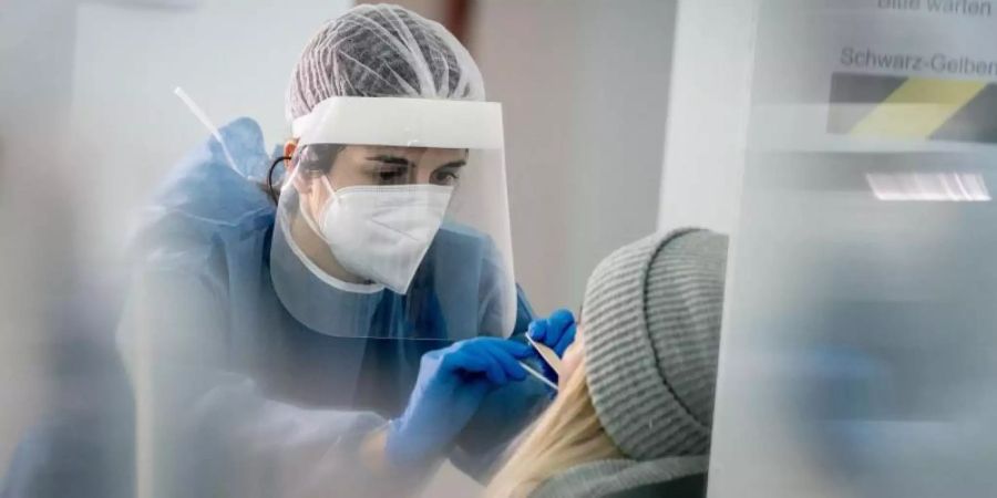 Medizinisch geschultes Personal nimmt in einer Galerie in Berlin-Mitte einen Mund- und Nasenabstrich für einen Corona-Schnelltest. Foto: Kay Nietfeld/dpa