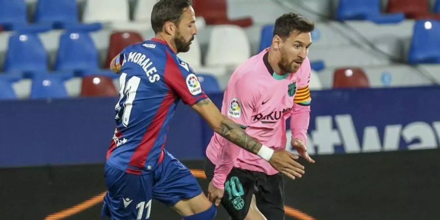 Levantes Jose Luis Morales (l) im Duell gegen Barcelonas Lionel Messi. Foto: Alberto Saiz/AP/dpa