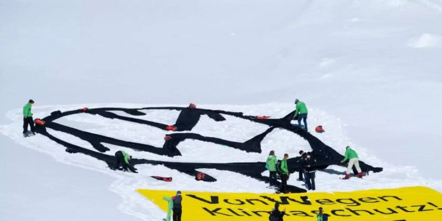 Greenpeace-Aktivisten haben auf dem Schneeferner-Gletscher an der Zugspitze ein VW-Logo und ein Banner mit der Aufschrift «VonWegen Klimaschutz» ausgerollt. Foto: Sven Hoppe/dpa
