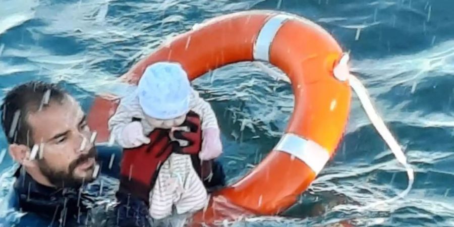 Migranten-Krise: Juan Francisco Valle, Taucher der spanischen Polizeieinheit Guardia Civil, rettet ein Baby. Foto: ---/Guardia Civil/dpa