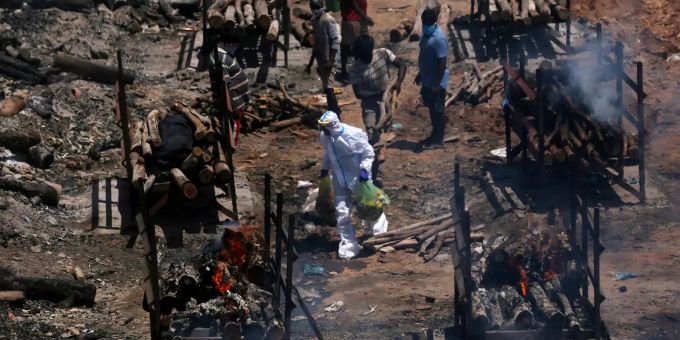 Angehörige vollziehen die letzte Ölung für COVID-19-Opfer während ihrer Beerdigung auf einem Masseneinäscherungsplatz in Giddenahalli am Stadtrand von Bangalore, Indien, 18. Mai 2021. Coronavirus in Bangalore