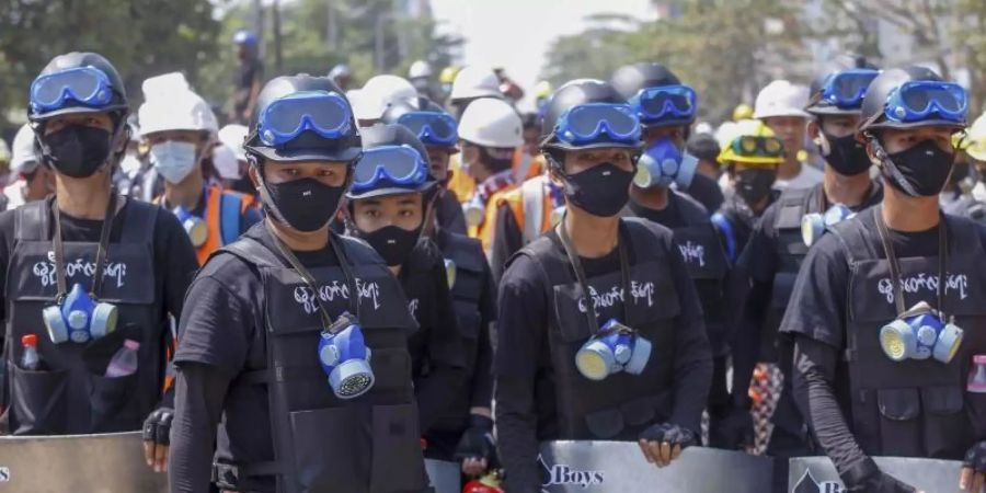 Anti-Coup-Demonstranten mit behelfsmässigen Schilden beziehen bei einem Protest gegen den Putsch der Militärjunta Stellung. Foto: Uncredited/AP/dpa