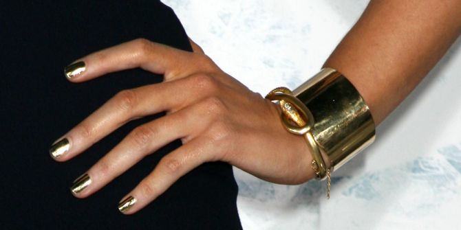 Handgelenk mit Schmuck aus Gold.