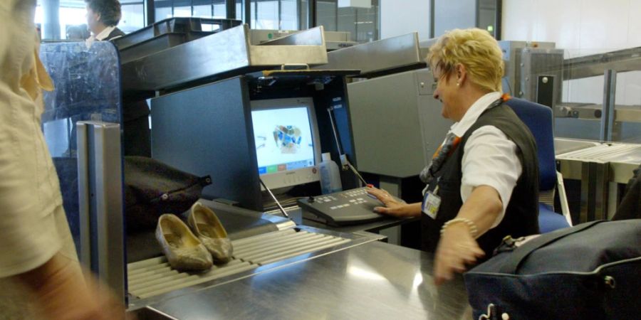 Eine Angestellte der Luftsicherheit kontrolliert Handgepäck am Flughafen in Frankfurt. (Archivbild)