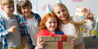 Kinder packen Geschenke aus.