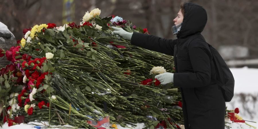 Eine Frau legt in Moskau Blumen für Alexej Nawalny nieder.