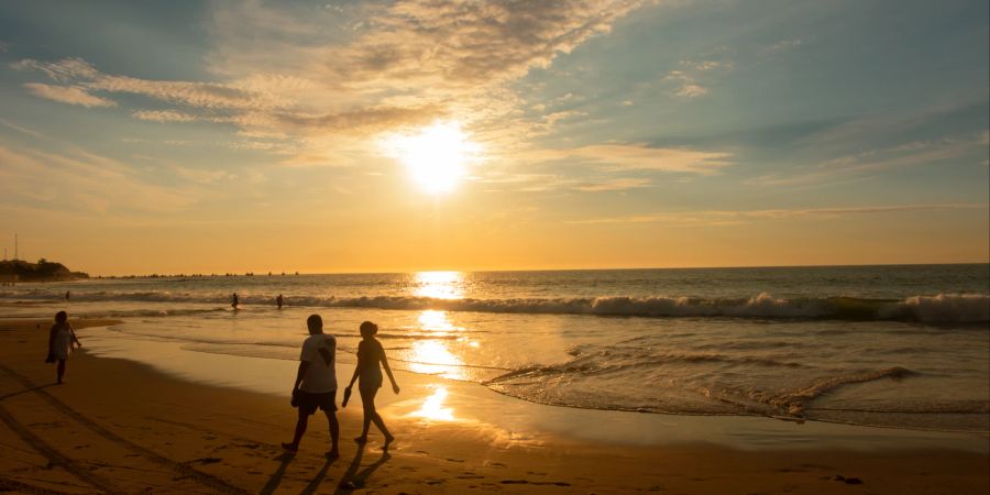 Paar im Sonnenuntergang am Strand.