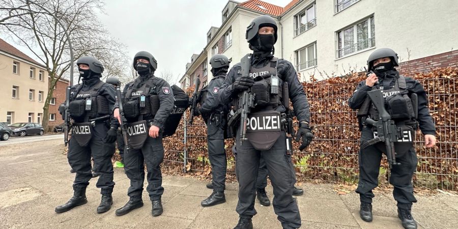 Polizisten stehen in der nähe des Tatorts in Billstedt, an dem zwei Männer durch einen Messerangriff tödlich verletzt worden sind.
