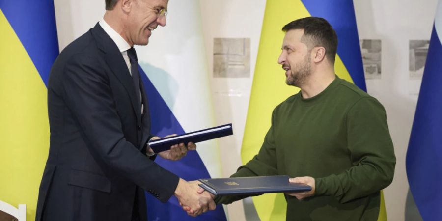 HANDOUT - Wolodymyr Selenskyj (r), Präsident der Ukraine, und Mark Rutte (l), Ministerpräsident der Niederlande, tauschen nach einer Unterzeichnungszeremonie Dokumente aus. Foto: Uncredited/Ukrainian Presidential Press Office/AP/dpa - ACHTUNG: Nur zur redaktionellen Verwendung und nur mit vollständiger Nennung des vorstehenden Credits