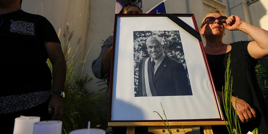 Ein Porträt des verstorbenen chilenischen Präsidenten Sebastian Pinera schmückt eine Gedenkstätte im Innenhof der Parteizentrale der Nationalen Erneuerung in Santiago, Chile. Foto: Esteban Felix/AP/dpa