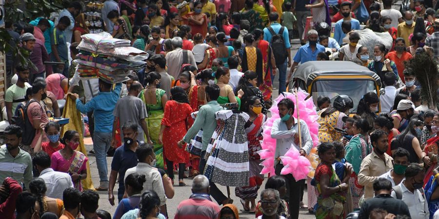 Menschen gehen dichtgedrängt auf einem Wochenmarkt im indischen Mumbai einkaufen.