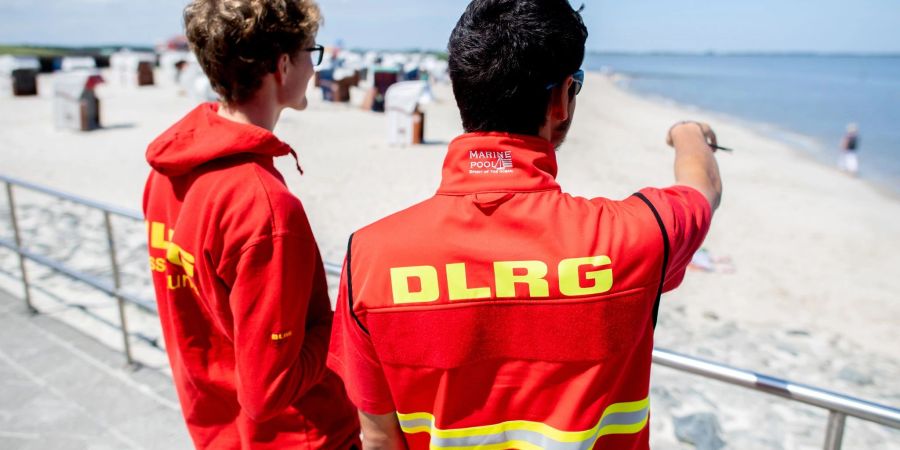 Zwei Rettungsschwimmer der DLRG bewachen einen Strand.