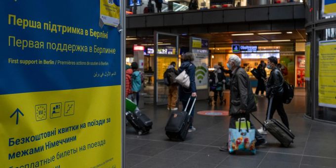 Berlin: Ein Plakat mit Informationen für die aus der Ukraine ankommenden Flüchtlinge hängt in der Bahnhofshalle am Hauptbahnhof, während im Hintergrund Reisende vorbeigehen. ukraine krieg
