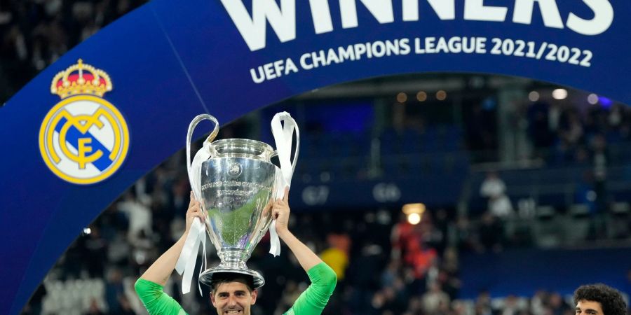 Real Madrids Torhüter Thibaut Courtois balanciert die Trophäe nach dem Sieg auf seinem Kopf.
