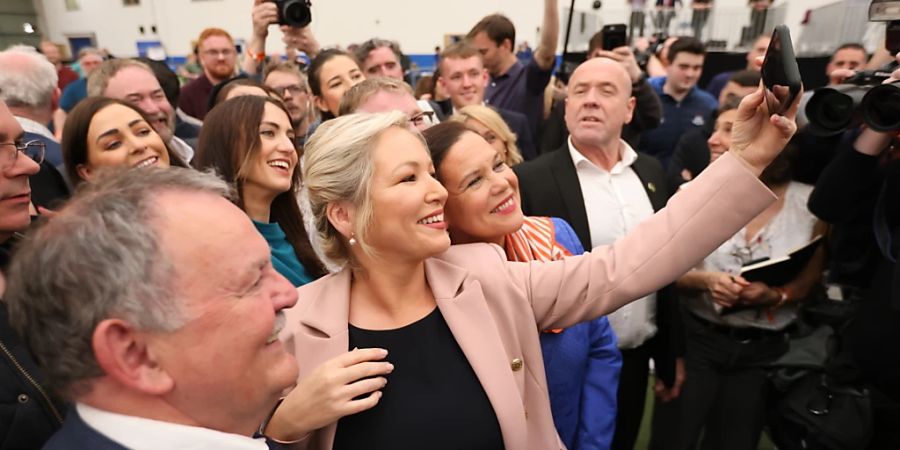 Michelle O'Neill (Mitte l), Spitzenkandidatin der nordirischen Partei Sinn Fein, und Mary Lou McDonald (Mitte r), Vorsitzende der nordirischen Partei Sinn Fein, machen ein Selfie im Meadowbank-Wahlauszählzentrum. Foto: Peter Morrison/AP/dpa