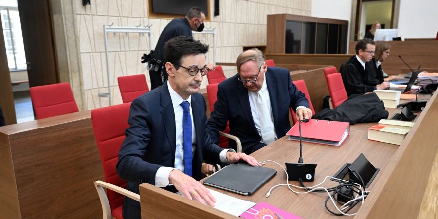 Bernhard Günther (l), ehemaliger Finanzchef von Innogy, und sein Rechtsanwalt Martin Meinberg (r) warten auf den Beginn des Prozesses in Wuppertal.